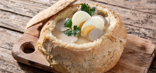 Żurek tradycyjna polska zupa z jajkiem i kiełbaską w chlebku, na drewnianym stole